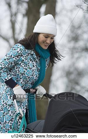 Mother pushing stroller in park View Large Photo Image Stock Photography - Mother pushing stroller in park. Fotosearch