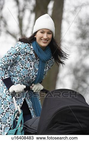 Mother walking with baby carriage in park, (portrait) View Large Photo Image Stock Image - Mother walking with baby carriage in park, (portrait). Fotosearch