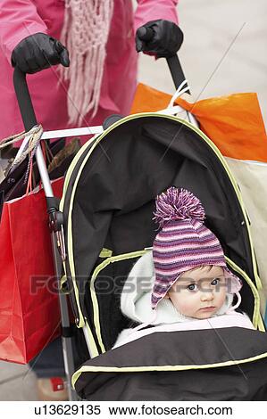 Stock Photography - Mother walking with baby in stroller, close up on baby. Fotosearch
