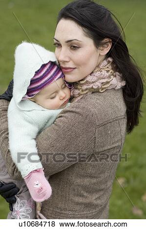 Mother with baby sleeping in her arms View Large Photo Image Stock Photo - Mother with baby sleeping in her arms. Fotosearch