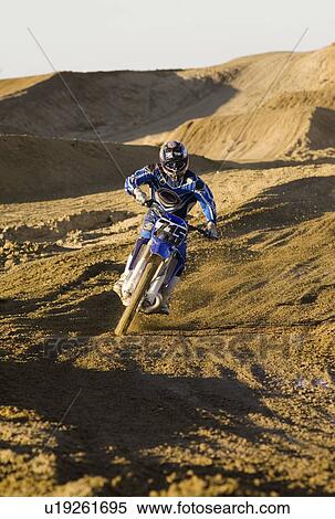 Stock Photography - Motocross racer riding on dirt track. Fotosearch