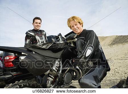 Motocross racers with bike, outdoors, (portrait) View Large Photo Image Stock Photo - Motocross racers with bike, outdoors, (portrait). Fotosearch