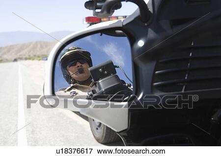 Stock Photo - Motorcycle police officers in wing mirror. Fotosearch