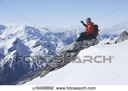 Mountain climber taking picture on mountain peak View Large Photo Image Stock Image - Mountain climber taking picture on mountain peak. Fotosearch