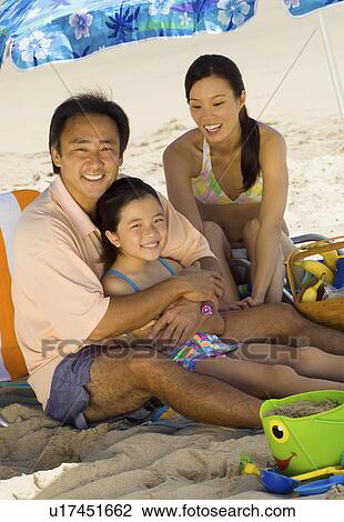 Parents with daughter (7-9) relaxing on beach, (portrait) View Large Photo Image Stock Image - Parents with daughter (7-9) relaxing on beach, (portrait). Fotosearch
