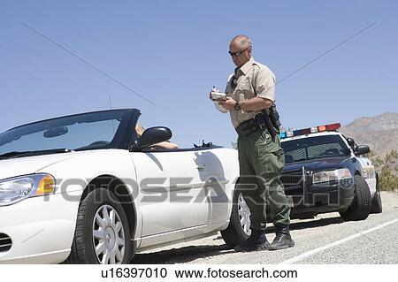 Stock Image - Patrol officer with convertible. Fotosearch