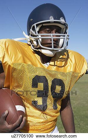 Player Holding Football on field View Large Photo Image Stock Image - Player Holding Football on field. Fotosearch