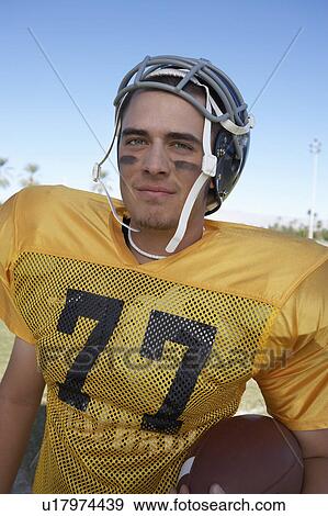 Stock Photo - Player Holding Football on field, portrait, (portrait). Fotosearch