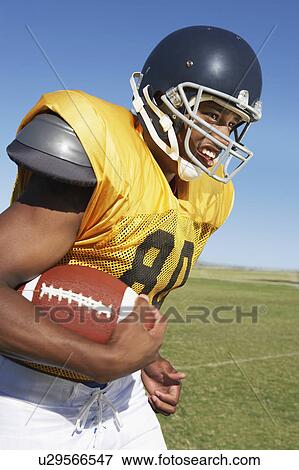 Player running with football on field View Large Photo Image Stock Photo - Player running with football on field. Fotosearch