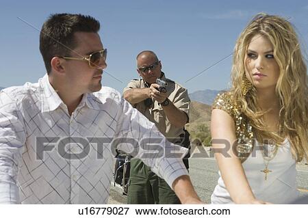 Police man aims gun at young couple View Large Photo Image Stock Photo - Police man aims gun at young couple. Fotosearch
