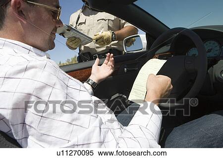 Stock Photography - Police man giving man speeding ticket. Fotosearch