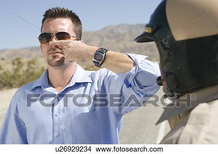 Picture - Police office runs sobriety test on male driver. Fotosearch