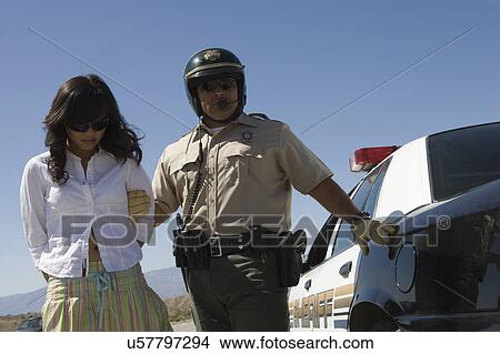 Picture - Police officer arrests female driver. Fotosearch
