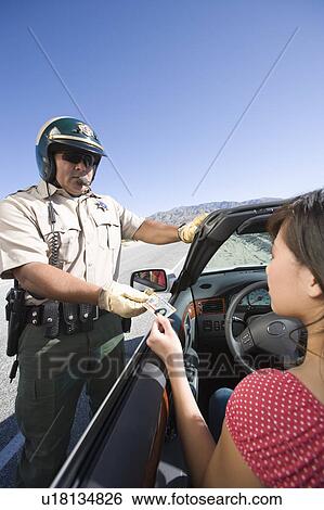 Stock Photograph - Police officer checking driver's ID. Fotosearch