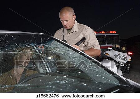 Police officer rescuing car accident victim View Large Photo Image Stock Photograph - Police officer rescuing car accident victim. Fotosearch