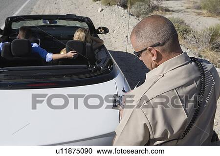 Stock Image - Police officer takes down car details. Fotosearch