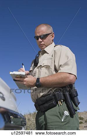 Stock Image - Policeman writing speeding ticket. Fotosearch