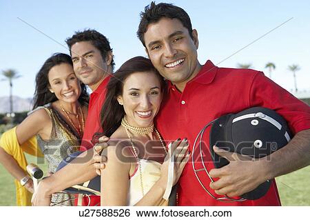 Polo Players standing, holding helmets, arms around Girlfriends outside View Large Photo Image Stock Photograph - Polo Players standing, holding helmets, arms around Girlfriends outside. Fotosearch