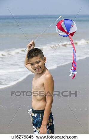 Stock Photography - Portrait of boy with kite on beach. Fotosearch