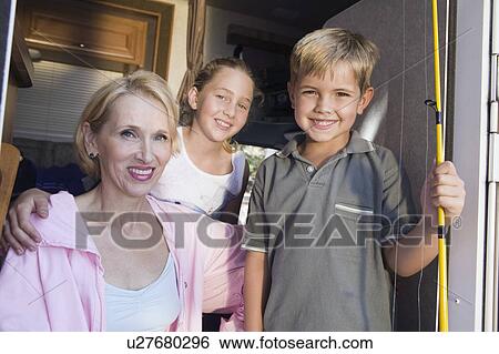 Stock Photograph - Portrait of mother and children in camper van. Fotosearch