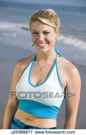 Stock Photo - Portrait of woman on beach, smiling. Fotosearch