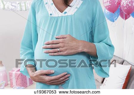 Pregnant Woman with Hands on Her Stomach, mid section View Large Photo Image Stock Image - Pregnant Woman with Hands on Her Stomach, mid section. Fotosearch
