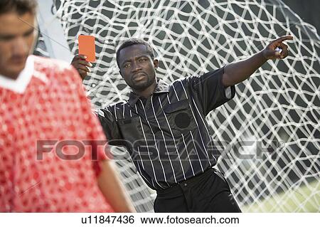 Stock Photograph - Referee holding out red card, dismissing player, portrait. Fotosearch