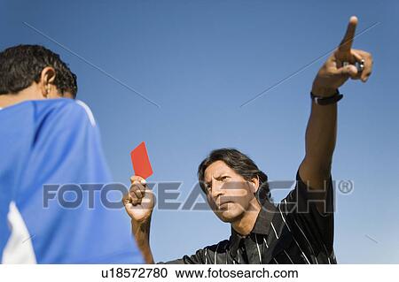 Stock Image - Referee holding up red card and pointing, portrait. Fotosearch
