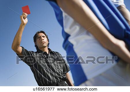 Referee holding up red card, portrait, low angle view View Large Photo Image Stock Photo - Referee holding up red card, portrait, low angle view. Fotosearch