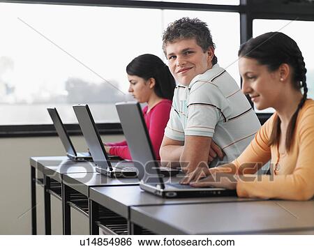 Row of teenage students using laptops in classroom View Large Photo Image Stock Photograph - Row of teenage students using laptops in classroom. Fotosearch