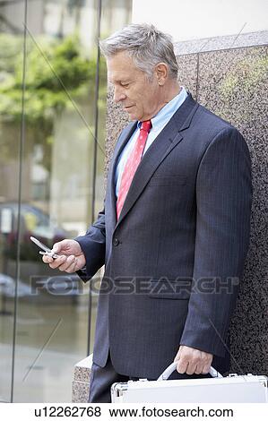 Senior businessman using cell phone, outdoors View Large Photo Image Stock Photo - Senior businessman using cell phone, outdoors. Fotosearch