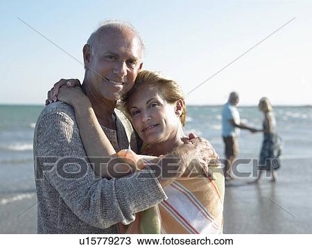Stock Image - Senior couple embracing on beach. Fotosearch
