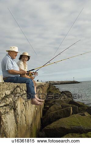 Stock Photography - Senior couple fishing at ocean. Fotosearch