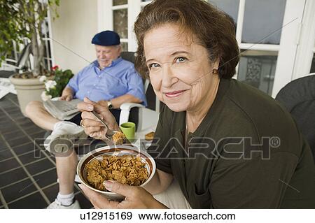 Stock Photo - Senior couple having breakfast on porch. Fotosearch