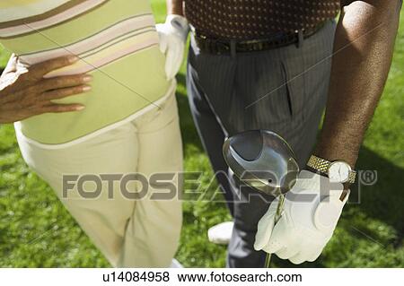 Stock Photo - Senior couple in golf course, (mid section), (elevated view). Fotosearch