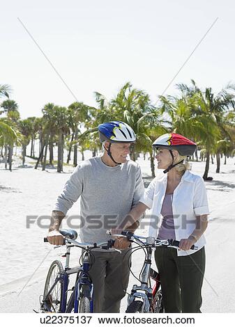 Senior couple on bicycles on tropical beach View Large Photo Image Stock Photo - Senior couple on bicycles on tropical beach. Fotosearch