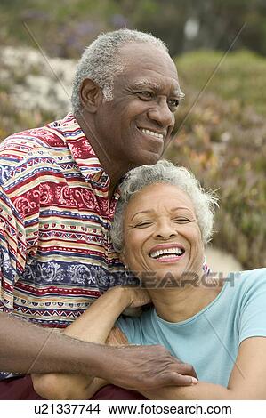 Senior couple relaxing outdoors, smiling View Large Photo Image Picture - Senior couple relaxing outdoors, smiling. Fotosearch