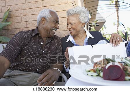 Senior Couple sitting outdoors on Shopping Trip, looking in eyes View Large Photo Image Stock Image - Senior Couple sitting outdoors on Shopping Trip, looking in eyes. Fotosearch