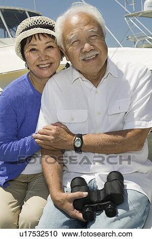 Senior couple with binoculars on boat, (portrait) View Large Photo Image Stock Image - Senior couple with binoculars on boat, (portrait). Fotosearch