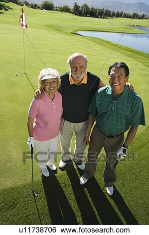 Senior couple with instructor on golf course, smiling, (portrait), (elevated view) View Large Photo Image Stock Photograph - Senior couple with instructor on golf course, smiling, (portrait), (elevated view). Fotosearch