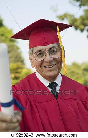 Stock Image - Senior Graduate holding diploma outside, portrait. Fotosearch