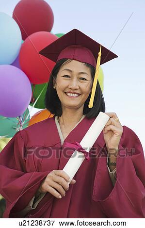 Stock Photo - Senior Graduate holding diploma outside, portrait. Fotosearch