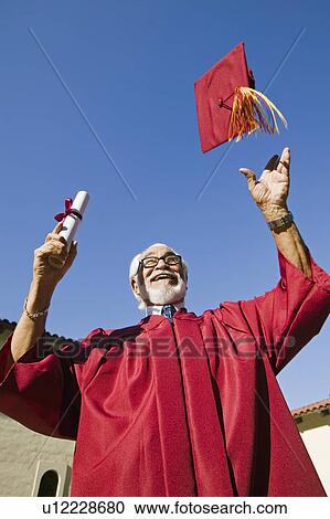 Senior graduate tossing hat in air outside, low angle view View Large Photo Image Stock Image - Senior graduate tossing hat in air outside, low angle view. Fotosearch