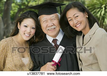 Stock Image - Senior Graduate with granddaughter and daughter outside, portrait. Fotosearch