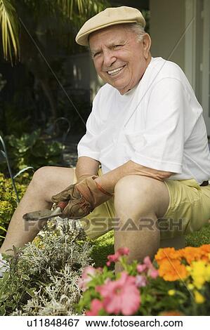 Stock Photo - Senior man gardening, (portrait). Fotosearch