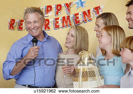 Senior man giving speech at retirement party in his honour, arms around wife, standing with family View Large Photo Image Stock Image - Senior man giving speech at retirement party in his honour, arms around wife, standing with family. Fotosearch