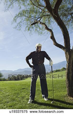 Stock Photography - Senior man on golf course, (portrait). Fotosearch