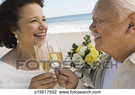 Senior newly weds toasting champagne at beach, (close-up) View Large Photo Image Stock Image - Senior newly weds toasting champagne at beach, (close-up). Fotosearch