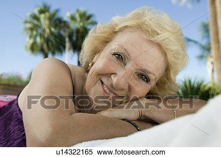 Stock Photography - Senior Woman Lying Down outdoors, close-up portrait.. Fotosearch