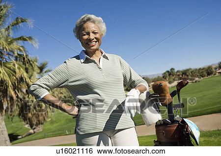 Stock Photograph - Senior woman on golf course, (portrait). Fotosearch